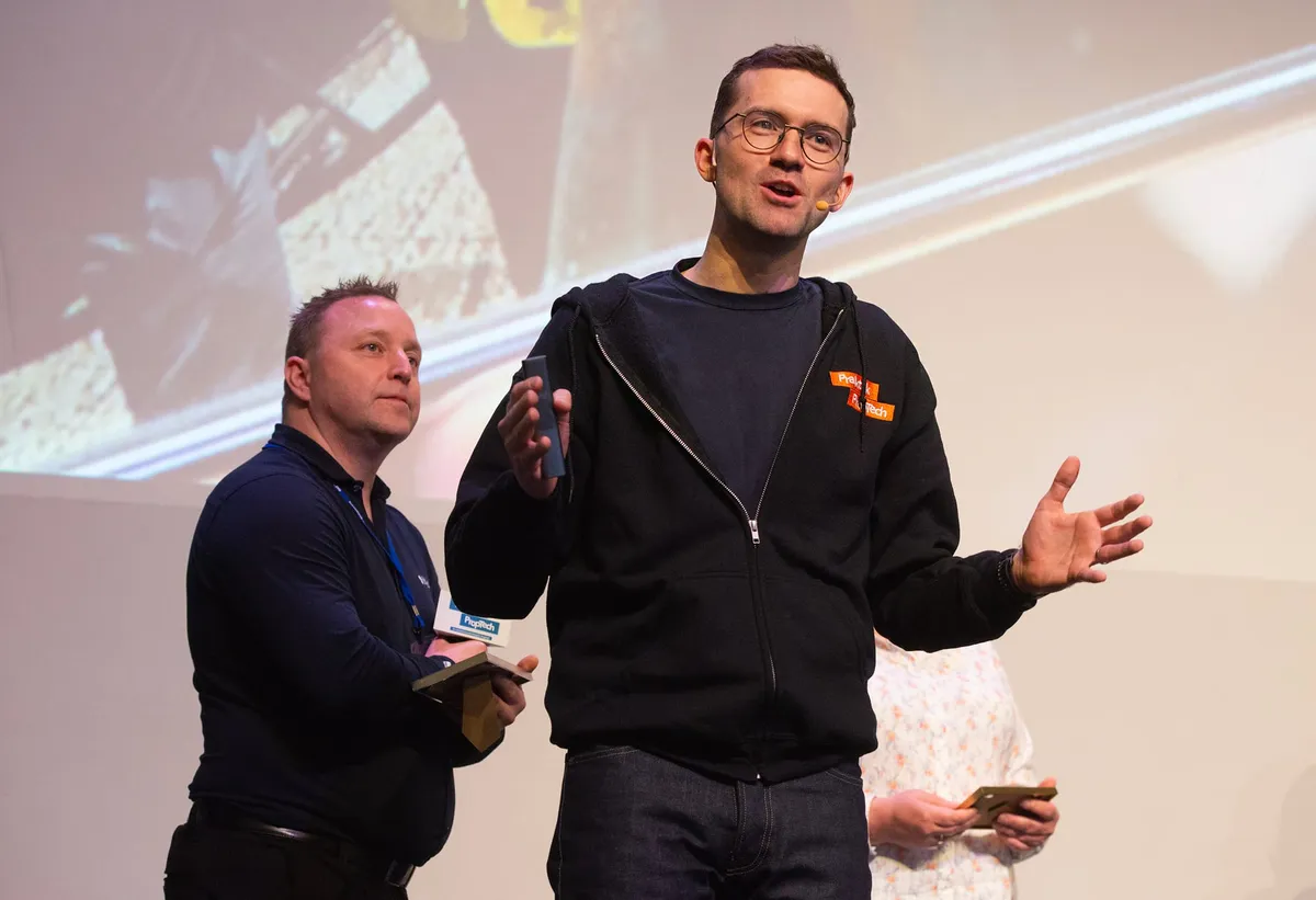 Martin på scenen på FDVkongressen 2024, med en foredragsholder bak seg