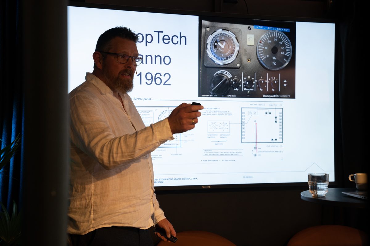 Atle Husabø foran sliden «PropTech anno 1962» med gamle målere