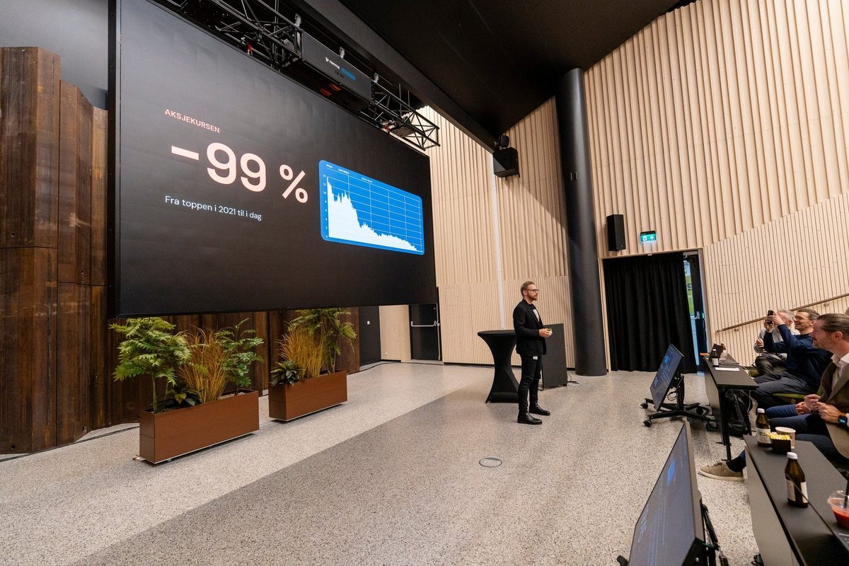 Joakim Lindh fra Airthings på scenen foran storskjermen med «−99 %»