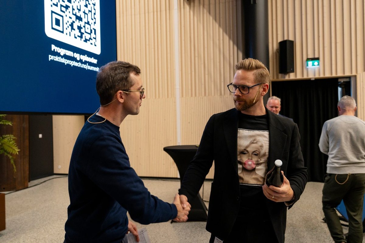 Martin håndhilser på Joakim Lindh foran storskjermen med QR-koden til programmet