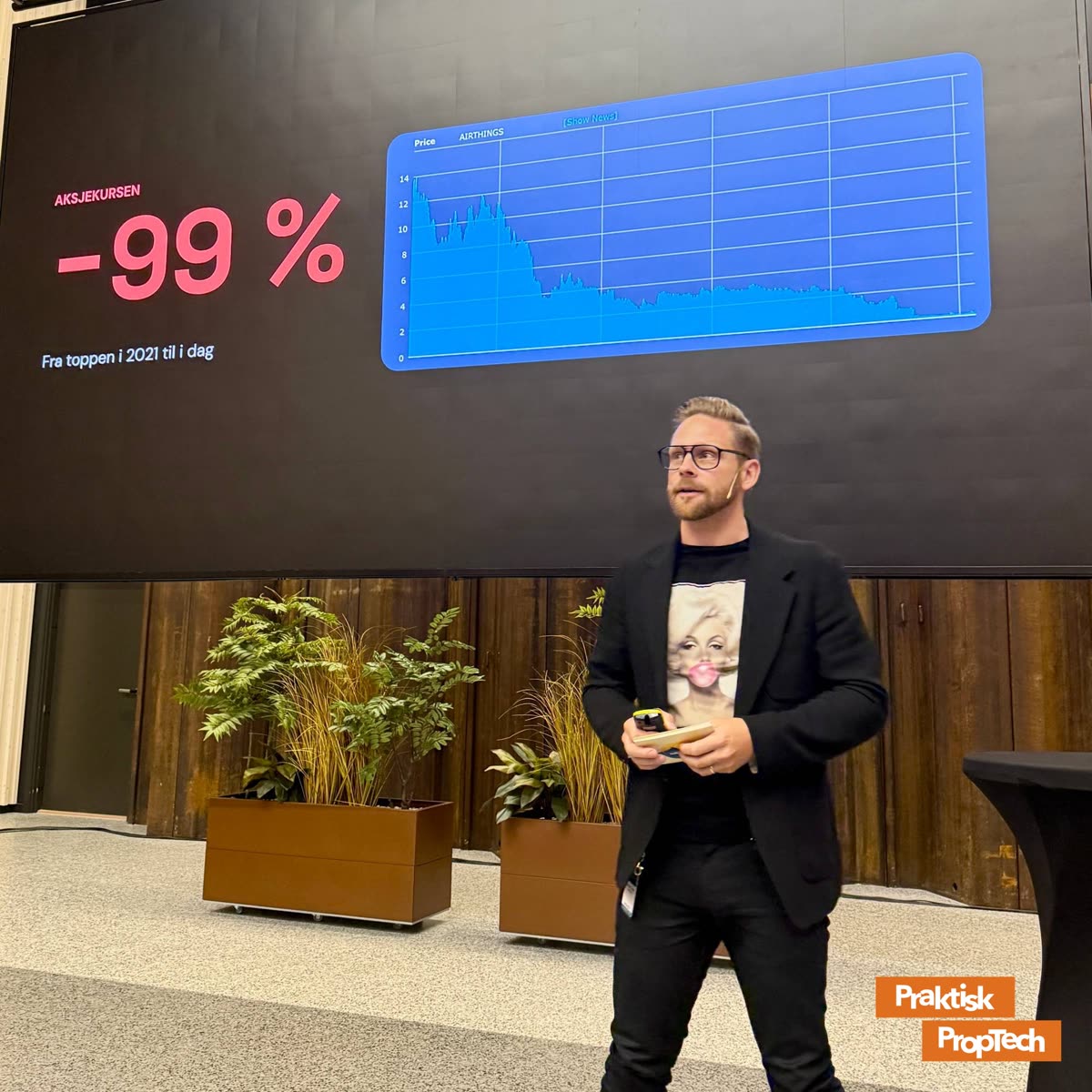 Joakim Lindh fra Airthings på scenen foran sliden «−99 %»